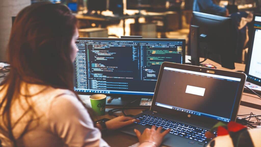 Girl at multiple computer screens.