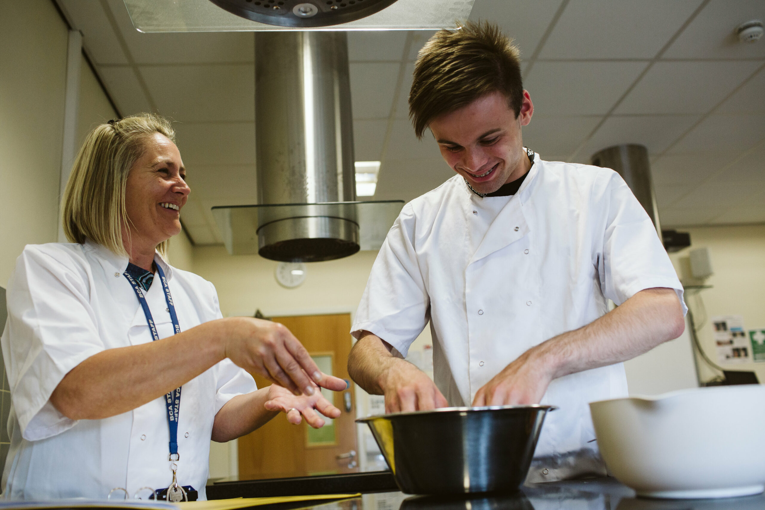 Foundation student in the kitchen supported by teacher