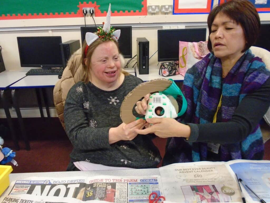 Student posing with artwork and teacher