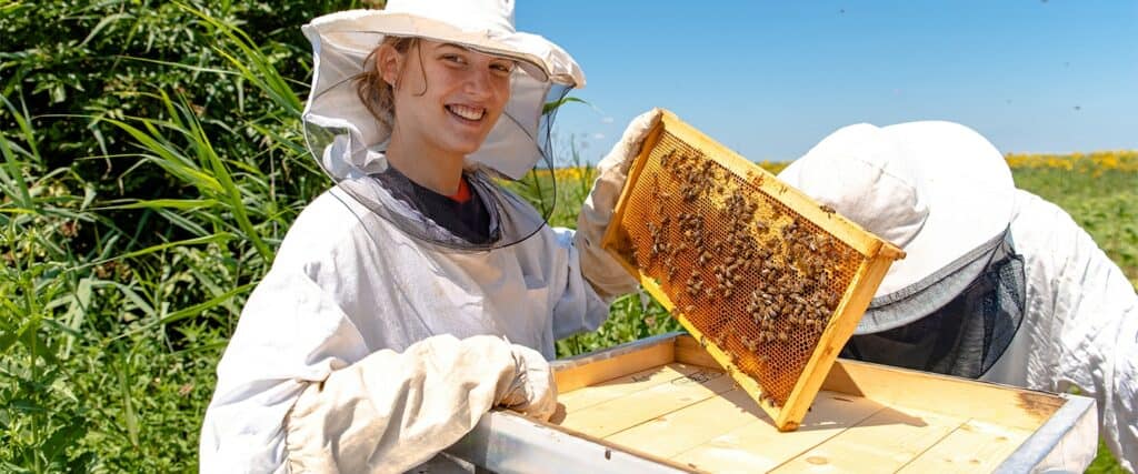 Beekeeper student holding honeycomb