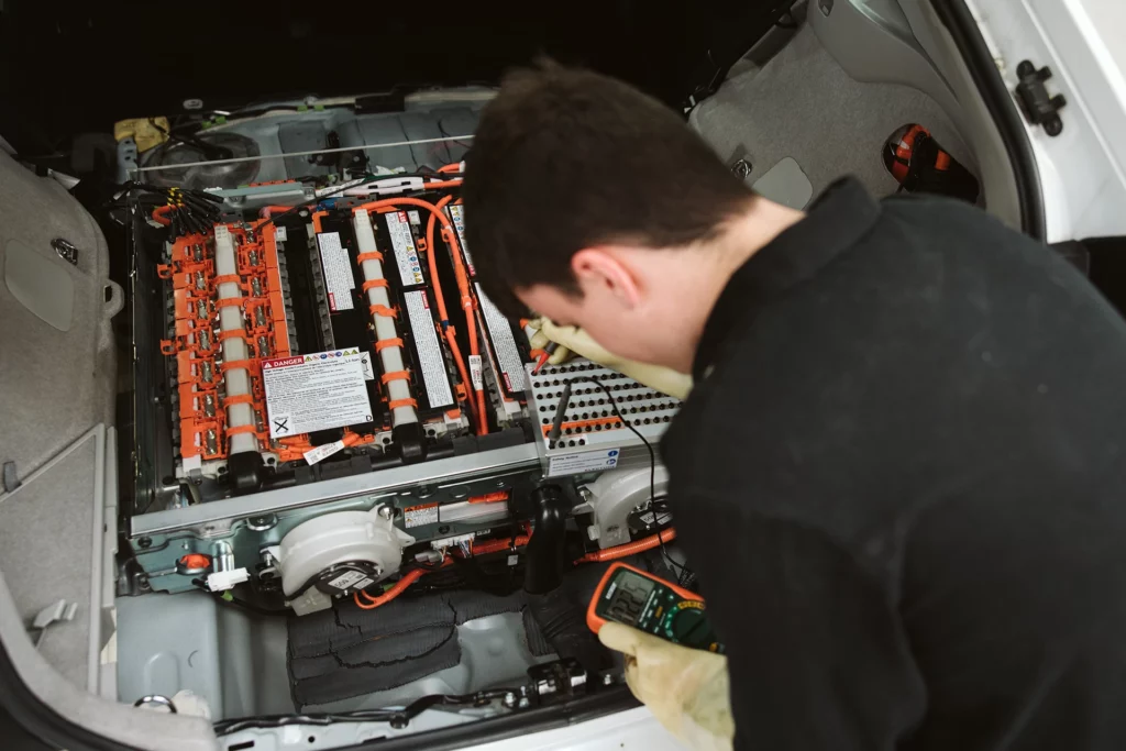 Electric vehicle training student working on Prius rig