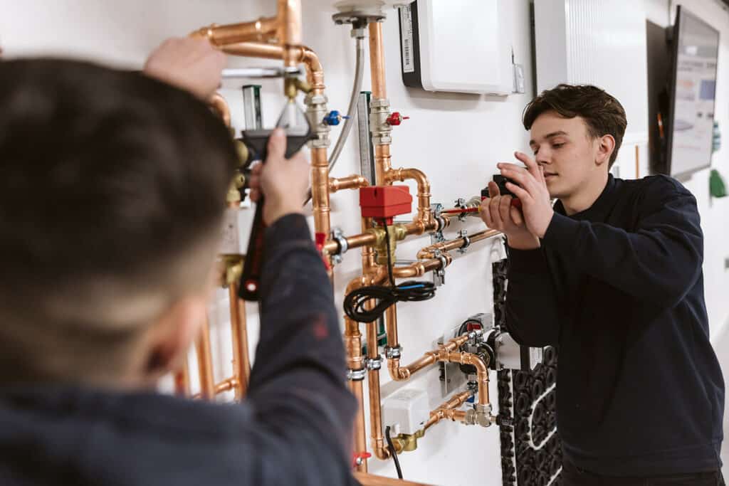 Plumbing students working on copper pipes