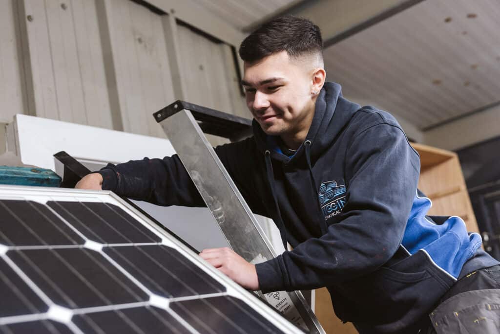 Student servicing solar panel