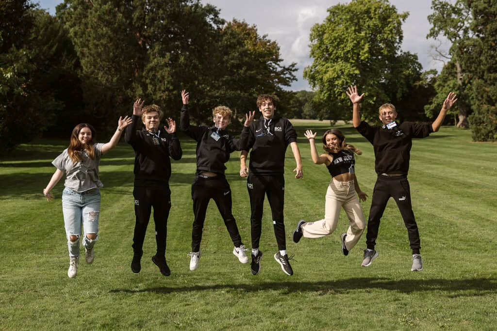 A group of people jumping in the air on the BCA lawn