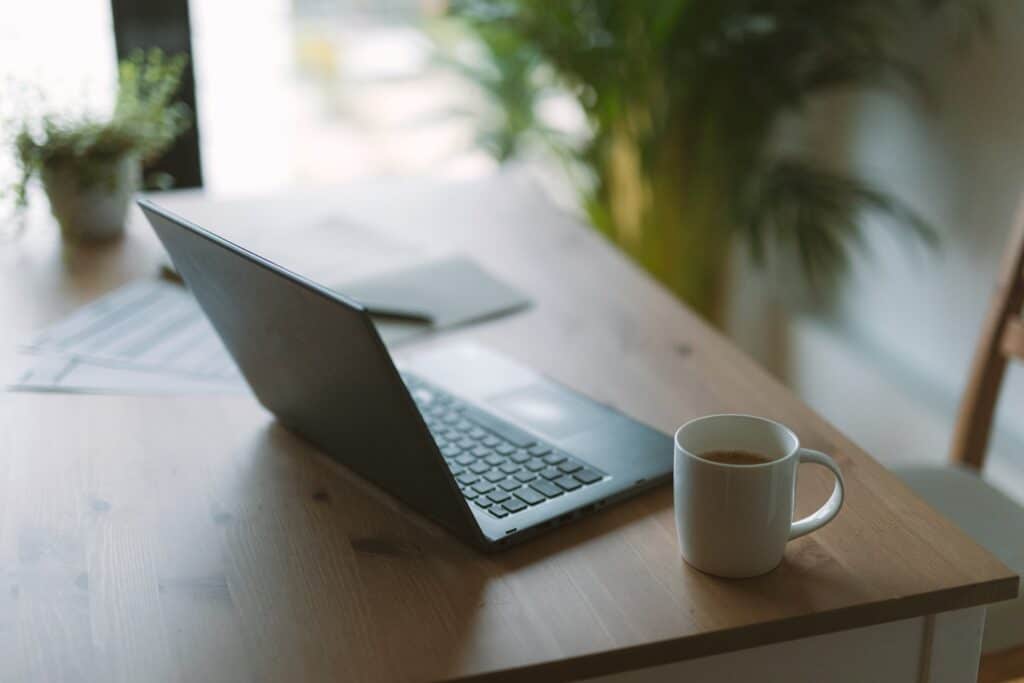 A computer and a cup of coffee on a desk