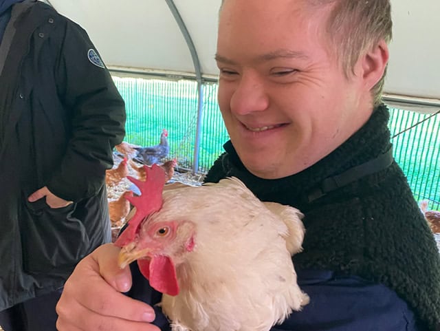 An ALFIE student holding a chicken