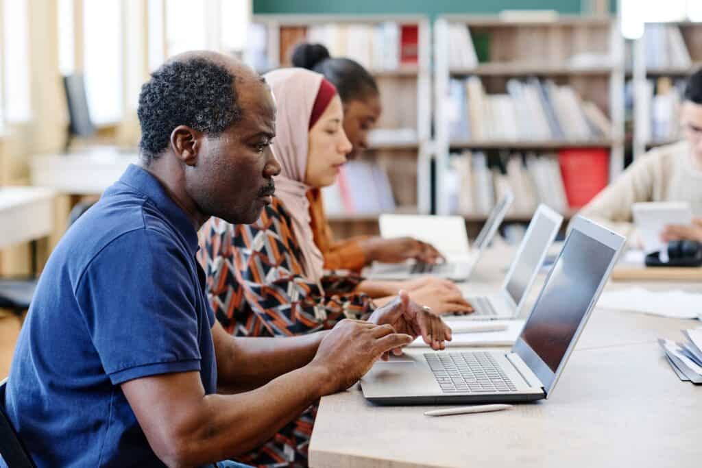A man sat studying at a laptop