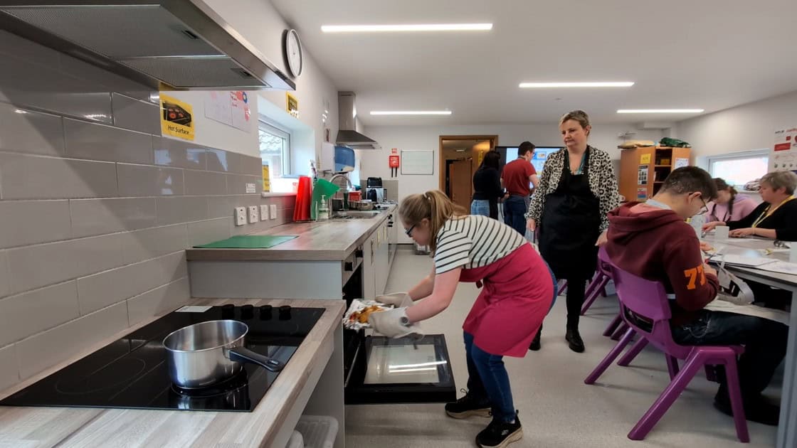 An ALFIE learner putting something in an oven