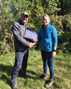 Two people shaking hands with a certificate