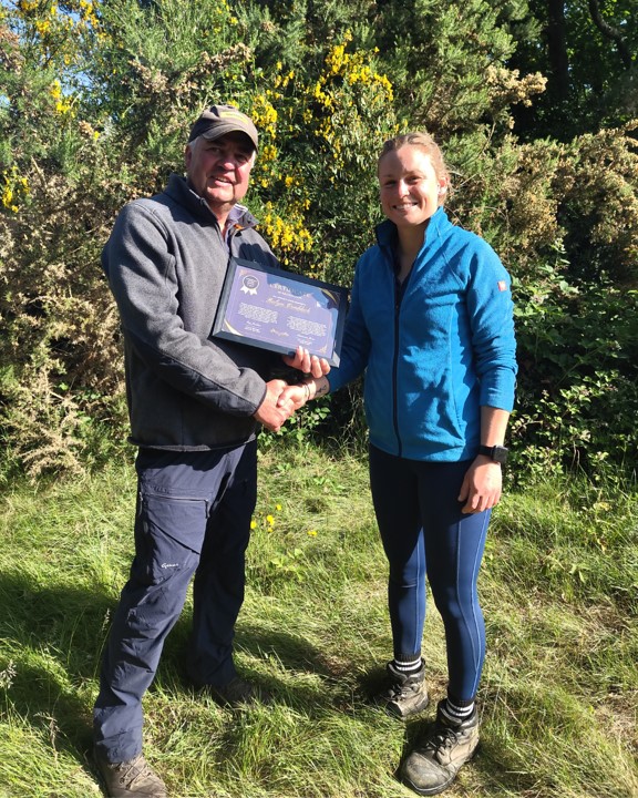 Two people shaking hands with a certificate