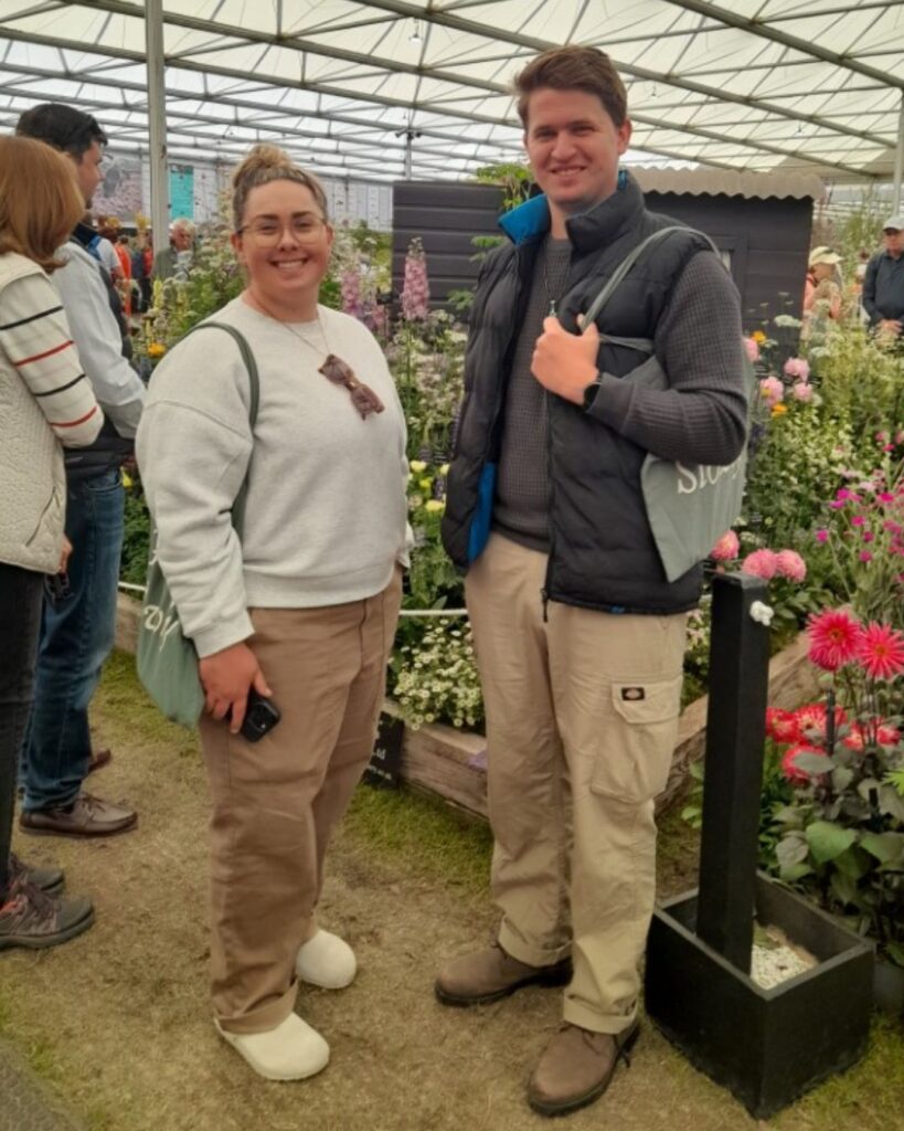 Two students smiling at the camera at the Chelsea Flower Show