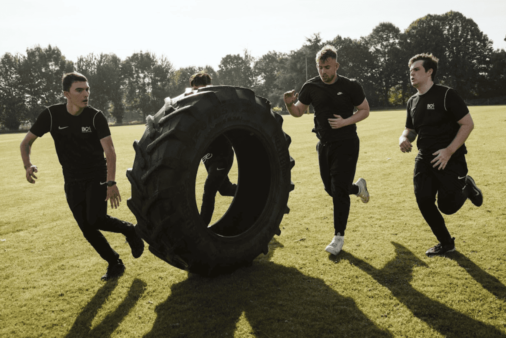 students running with a tyre