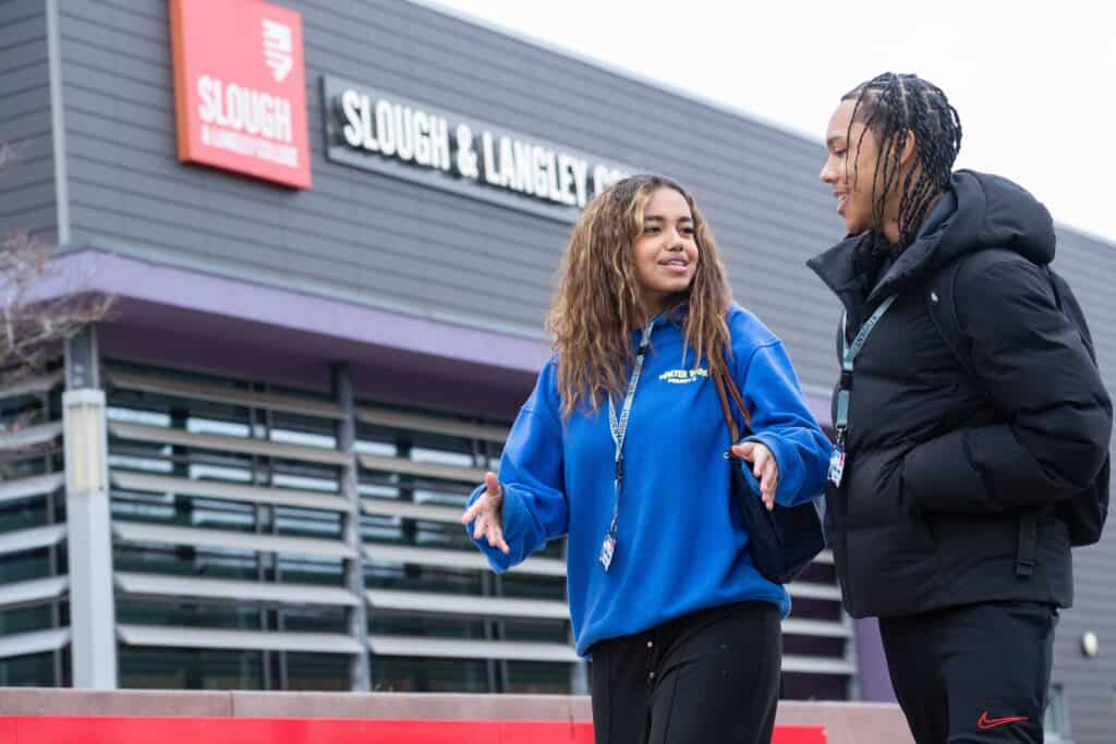 2 students walking in from of S&L college
