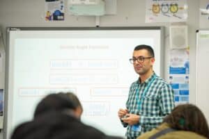 student at a white board teaching maths