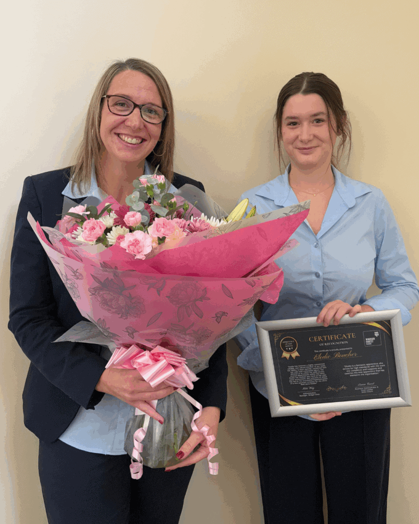 Elodie holding her certificate and some flowers whilst stood next to Kate from The Bridge Clinic, smiling to the camera