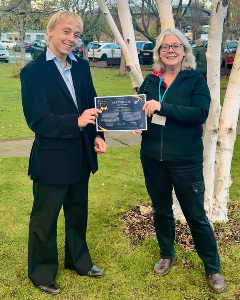 Apprentice of the Month with his certificate and the skills coach