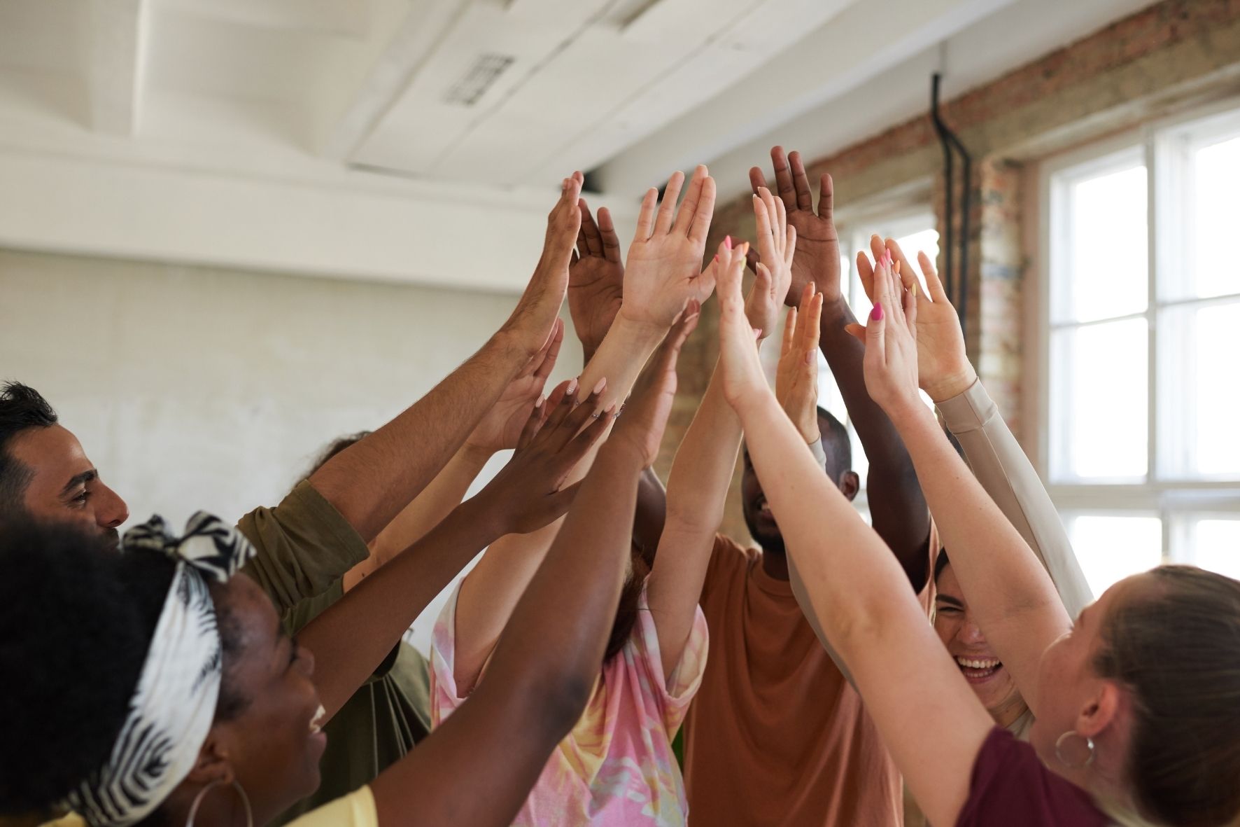 Group oif adults high fiving in the middle of a room