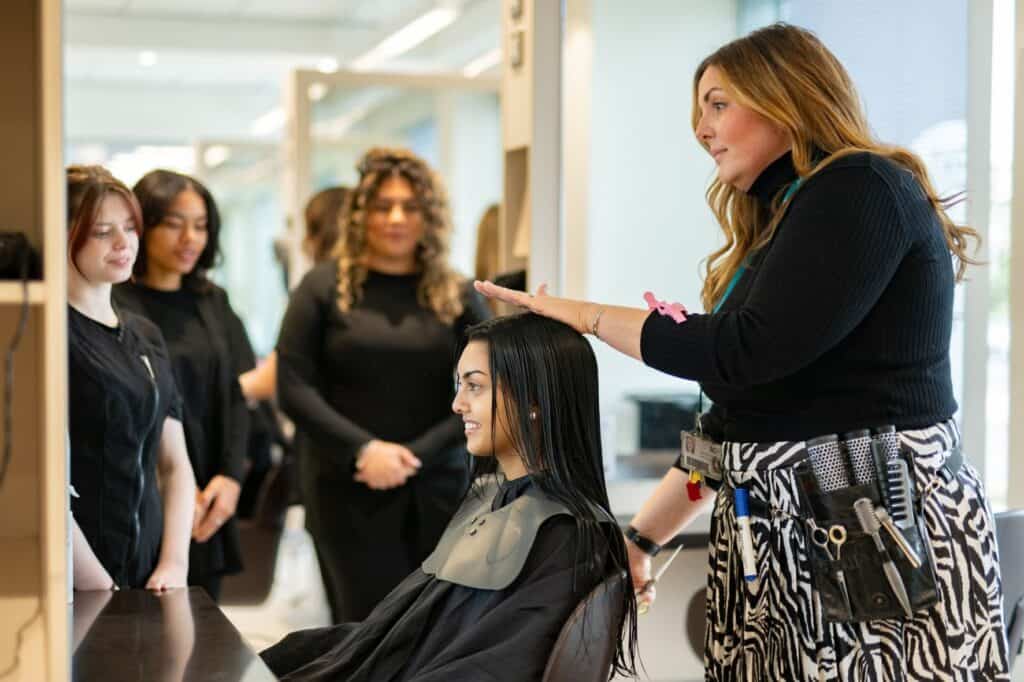 Hairdressing students learning a technique