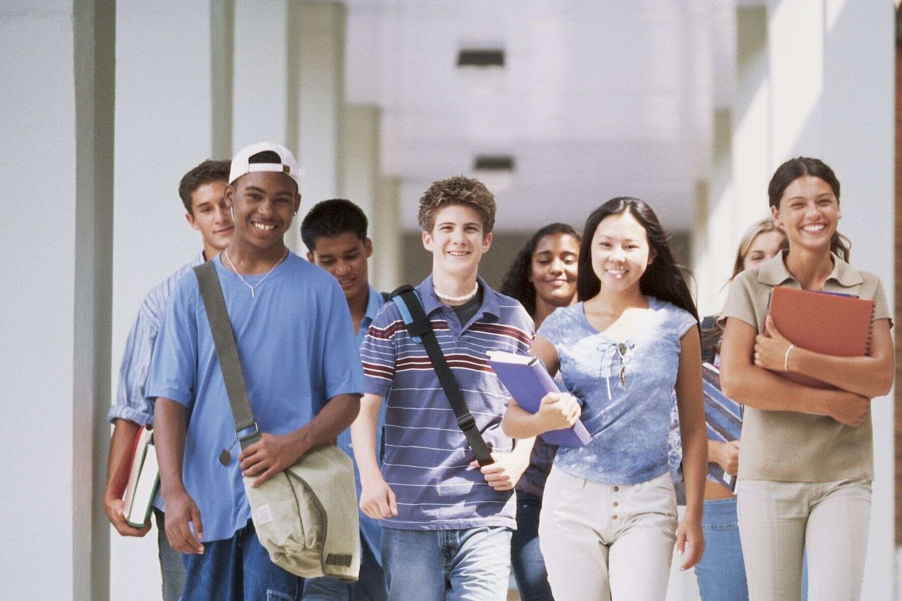 Group of young students walking along a hallway