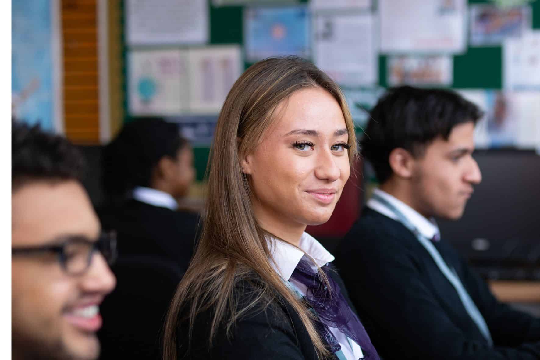 3 students with one looking at camera and smiling